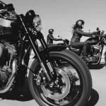 black and white photo of people riding motorcycle